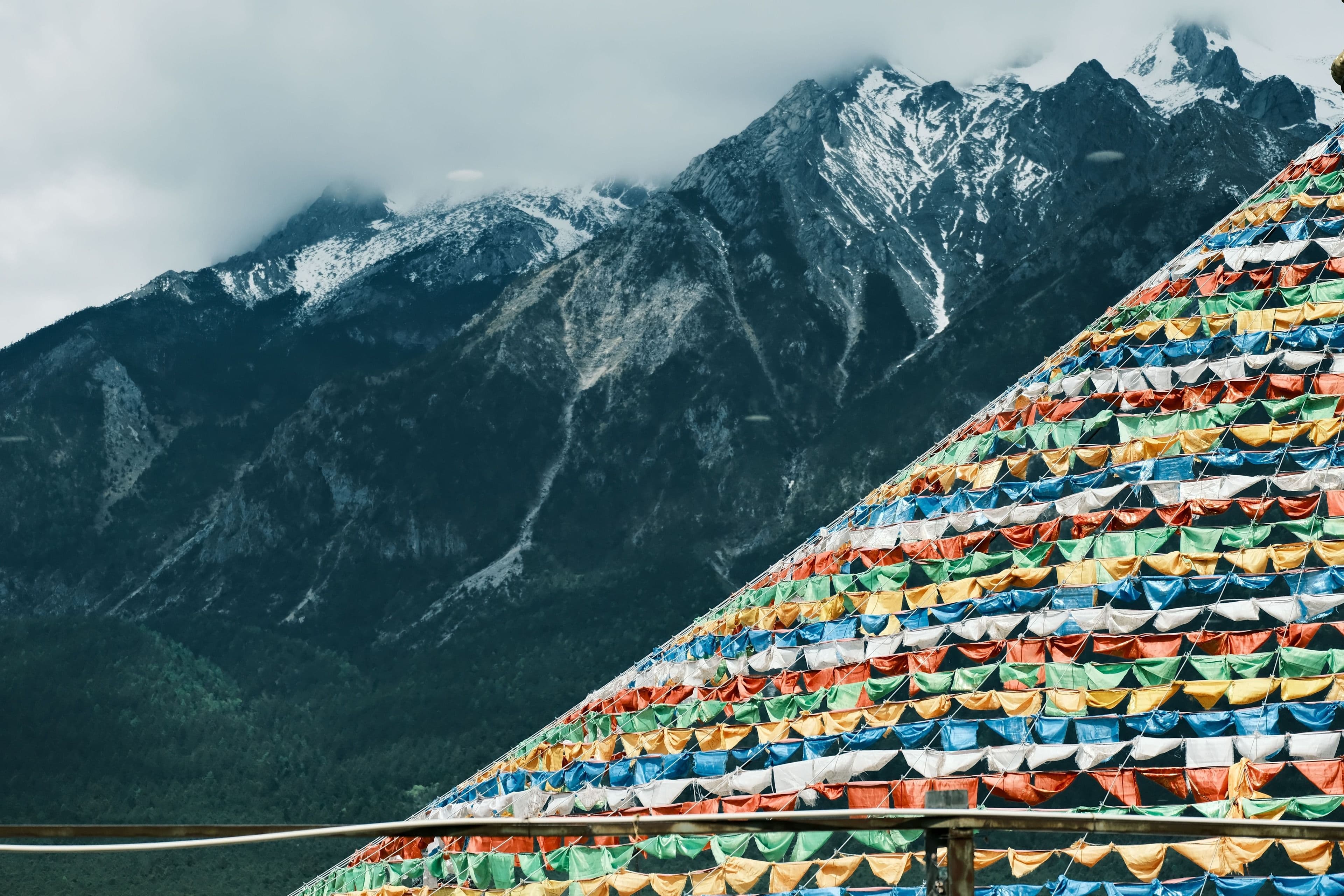 Tibetan prayer flags below snow peaks